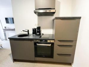 a kitchen with a sink and a stove at Studio Sarrazine - N5 in Alençon
