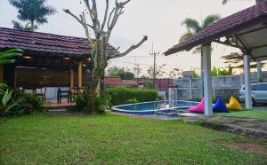 a backyard with a pool with colorful trampoline at Villa Ananda 1, 3 KT Kolam Renang, Karaoke Biliar in Cisarua +36 photos