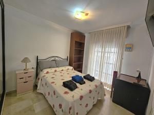a bedroom with a bed and a dresser and a window at ALMERIA CENTRO y CONFORT in Almería