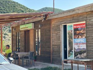 a building with a table and chairs outside of it at Camping Lekdushi - Shehu in Tepelenë
