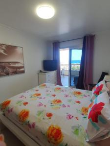 een slaapkamer met een bed met bloemen erop bij Comfortable apartment with amazing sea views in Palm-mar +56 foto's