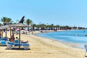 un grupo de personas sentadas en una playa en Villa La Paz, en San Javier