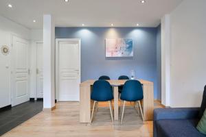 een eetkamer met een tafel en blauwe stoelen bij Apartment in Old Lille in Lille