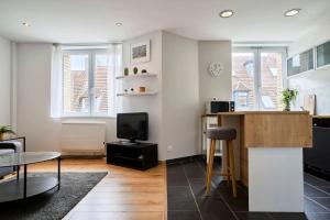 een woonkamer met een tafel en een tv bij Apartment in Old Lille in Lille