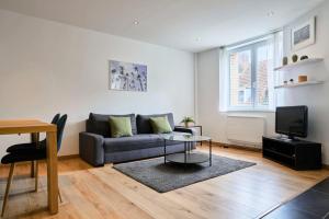 een woonkamer met een bank en een tafel bij Apartment in Old Lille in Lille