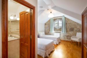 sypialnia z 2 łóżkami i łazienką w obiekcie Casa dos Maza w mieście Cambados