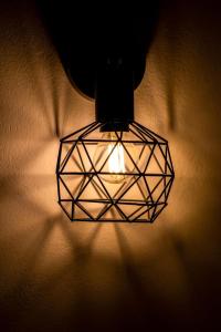 eine Leuchte, die an einer Wand hängt in der Unterkunft Dazzling Santorini Villa Villa Luck 2 Bedrooms Furnished Interiors in Perissa