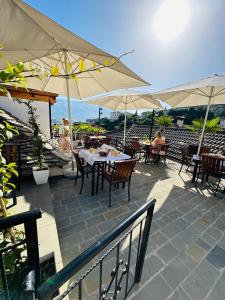 a patio with tables and chairs and umbrellas at Kore Guest House in Gjirokast&euml;r