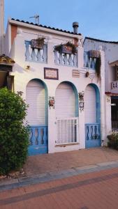 a white and blue building with three garage doors at Apartamento Torre la Sal in Cabanes +7 photos
