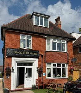a brick building with a sign that reads the singapore hotel at The Singlecote Hotel in Lincolnshire