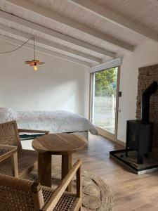 a bedroom with a bed and a table and a fireplace at Cabaña El galpon - Villa Meliquina de Espacio Bandurrias - in Villa Meliquina +85 photos