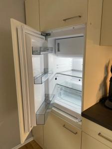 an empty refrigerator with its door open in a kitchen at "Haus Bella" in Cochem