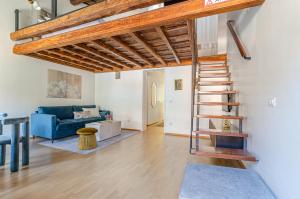 sala de estar con sofá azul y escalera de caracol en Domus Beato Angelico, en Roma