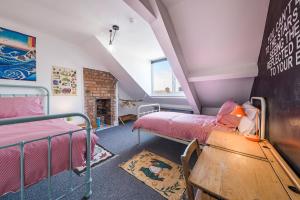 a attic room with two beds and a fireplace at Pats Palace in Whitley Bay
