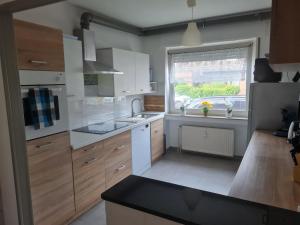 a kitchen with white cabinets and a sink and a window at Ferienwohnung Eulennest in Krefeld