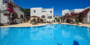 a large blue swimming pool in front of buildings at Smaragdi in Perivolos