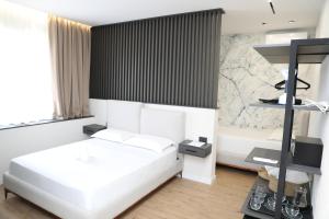 una camera con letto bianco e vasca di Hotel Scutari a Shkodër