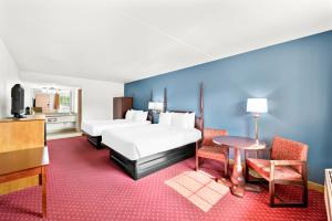 a hotel room with a bed and a table and chairs at Clarion Inn Branson in Branson