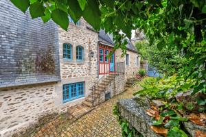 an old stone building with a red door and stairs at Ar Barzh Kadiou III in Quimper
