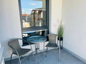 balkon ze stołem i krzesłami oraz oknem w obiekcie Złote Apartamenty 58 w mieście Legnica +3 zdjęcia