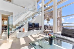 Una sala de estar con un sofá y un televisor. en Penthouse Duplex with Epic Views, en Barcelona