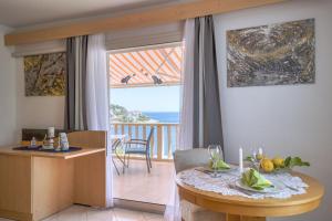 een woonkamer met een tafel en uitzicht op de oceaan bij Apartmani Marelic - Sun Beach in Zavalatica