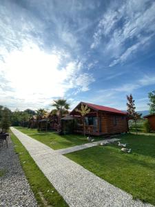 a log cabin with a gravel path in front of a house at Sapanca Göldibi Suit Bungalov in Sakarya