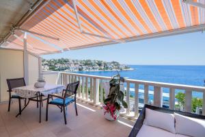 een balkon met een tafel en stoelen en de oceaan bij Apartmani Marelic - Sun Beach in Zavalatica