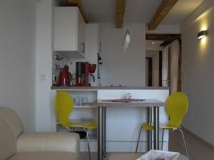 een keuken met gele stoelen en een tafel in een kamer bij Winzerhäusle Meersburg in Meersburg