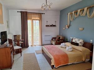 a bedroom with a bed and a living room at Hotel Metoxi in Spiliá