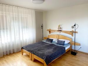 a bedroom with a bed with a wooden headboard at Nidos burė in Nida