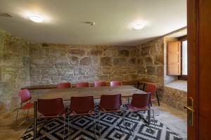 sala konferencyjna z drewnianym stołem i czerwonymi krzesłami w obiekcie Casa dos Maza w mieście Cambados