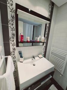 un bagno con un lavandino bianco e uno specchio di Karray Home Appartement Salon 2 RDC avec Jardin a Hammamet