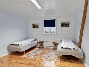 a bedroom with two beds and a rug at Arctic Ocean Lodge in Skjolde