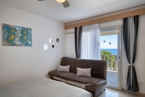 een slaapkamer met een bed, een bank en een raam bij Apartmani Marelic - Sun Beach in Zavalatica +112 foto's