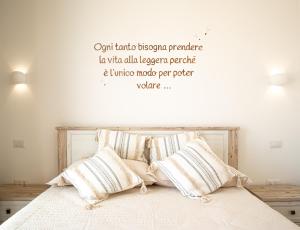 Il Soffione في كاستيلساردو: غرفة نوم بسرير مع اقتباس على الحائط