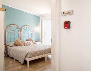a bedroom with a bed and a sign on the wall at Il Soffione in Castelsardo