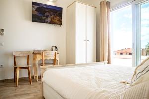 Il Soffione في كاستيلساردو: غرفة نوم بها سرير ومكتب ونافذة