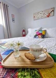 a tray with a tea cup and cookies on a bed at On the Rocks Overlooking the Sea in Twillingate