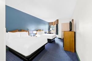 a hotel room with two beds and a flat screen tv at Clarion Inn Branson in Branson +14 photos