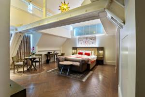a bedroom with a king sized bed and a table at The LaLit London - Small Luxury Hotel of the World in London