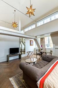 a living room with a couch and a tv at The LaLit London - Small Luxury Hotel of the World in London