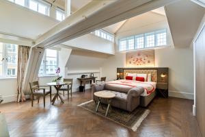 a large bedroom with a bed and a table at The LaLit London - Small Luxury Hotel of the World in London