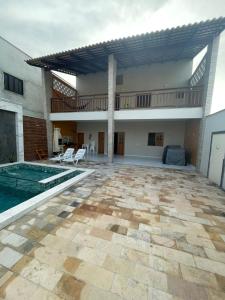 a patio with a swimming pool and a house at Wing haouse in Cruz