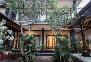 a building with trees and plants in a courtyard at Winsta Homestay in Ubud