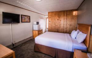 a hotel room with a bed and a television at The Superior Motel in Munising