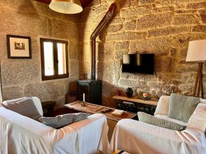a living room with two chairs and a table at Casa María da Reza in Ribadavia