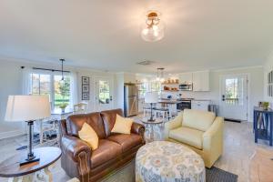 a living room with a couch and chairs and a kitchen at Modern Clarkesville Cottage with Decks and Patio! in Lakemont