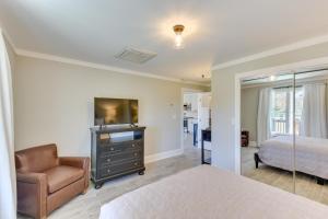 a bedroom with a bed and a chair and a television at Modern Clarkesville Cottage with Decks and Patio! in Lakemont