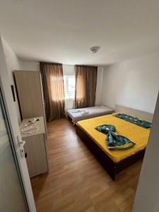 a bedroom with two beds and a yellow bedspread at Vila alexandra in Eforie Nord